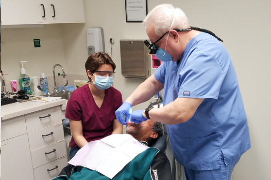 dentist performing oral health cleaning with a patient